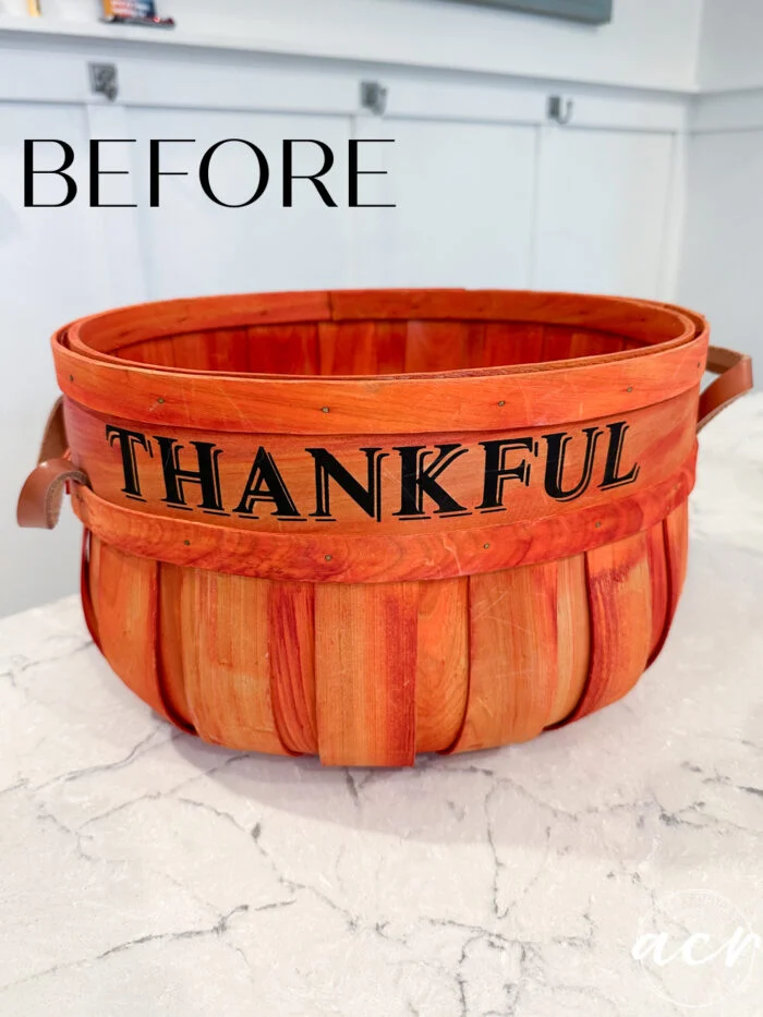 a wooden basket with the word thankful in black letters sits on a white countertop, featuring a fresh basket update for spring. the word before is written in large black letters above the basket.