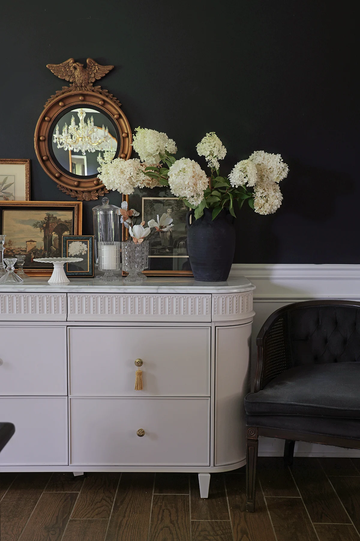 sideboard buffet with gold federal mirror above and armchair on the side