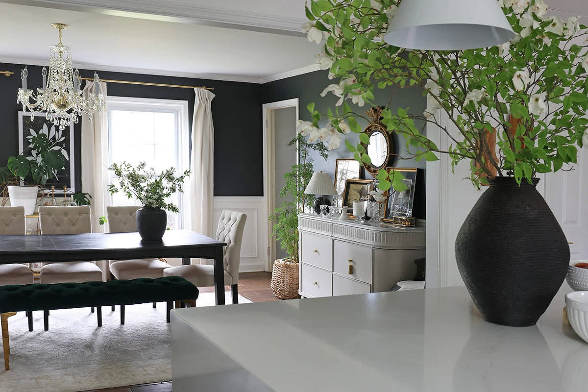 dining room looking from a kitchen area over a countertop with a vase of flowers