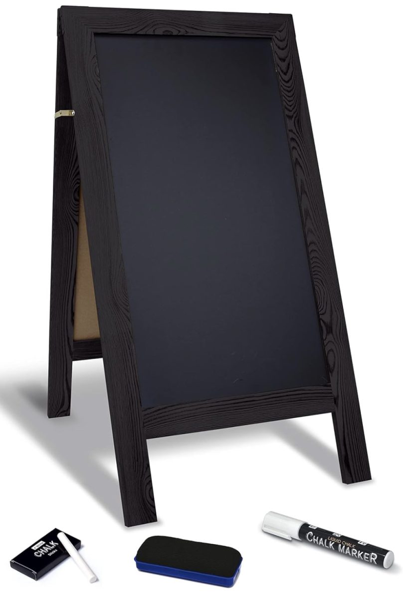 11 things i wish i bought sooner (april edition) 5 a black wooden a-frame chalkboard sign stands upright, with a chalk eraser, a white chalk marker, and an open box of chalk placed in front of it on a white background.