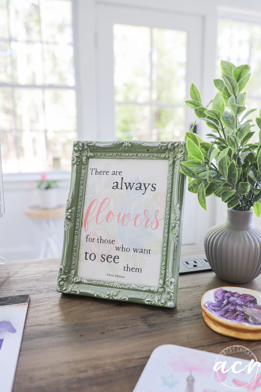 office reveal (sunroom) - artsy chicks rule® 62 a decorative picture frame with a quote sits on a wooden desk in this sunroom-inspired office reveal, next to a small potted plant. the quote reads, there are always flowers for those who want to see them. sunlight streams through the window behind.