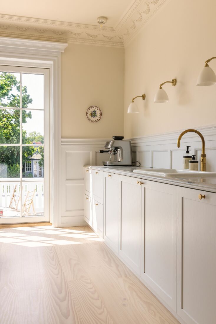 lining the kitchen walls are gubi bestlite bl wall lamps. the countertops are m 19