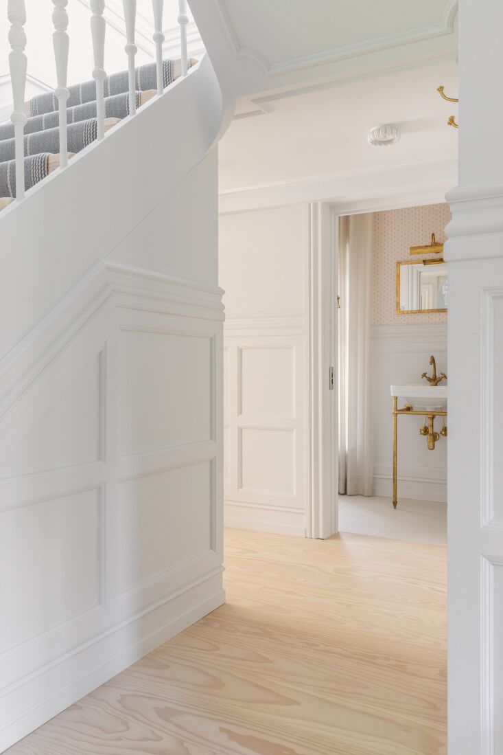 the downstairs powder room is designed with unlacquered brass faucet and edward 21