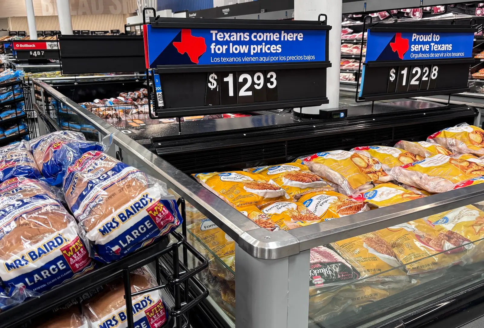 packages of chicken fingers at a supermarket in texas, with a sign "texans come here for low prices" above the food