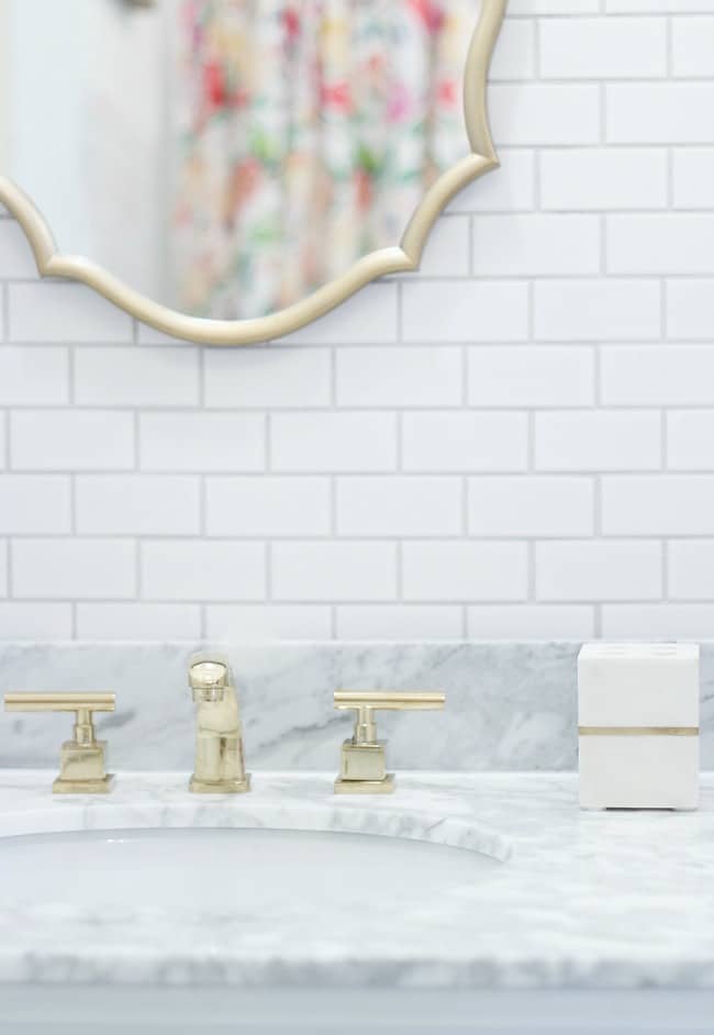 we added brass faucets and gold accents to compliment the white tile and counters.