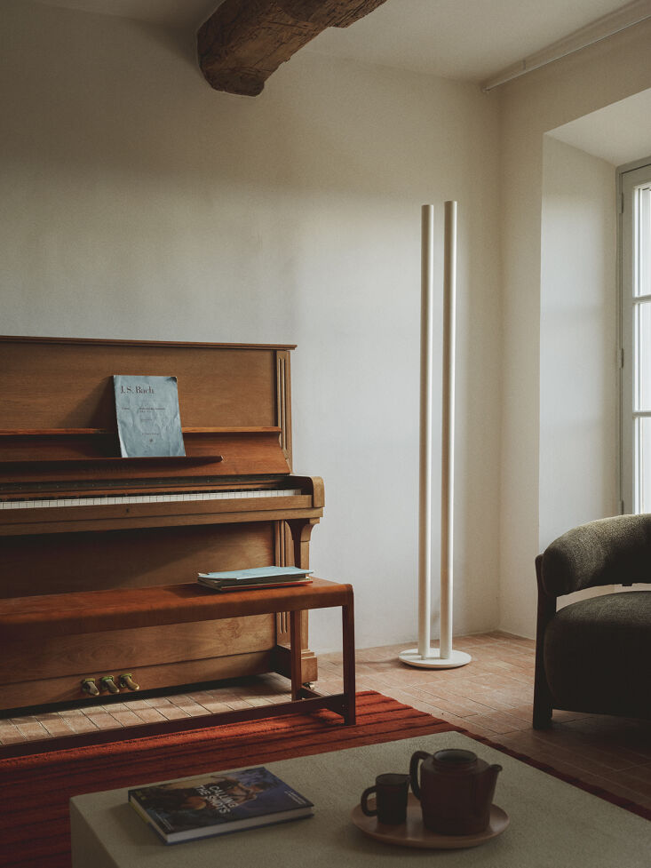the frama bench 01 in warm brown birch serves as a piano seat and the floor la 18