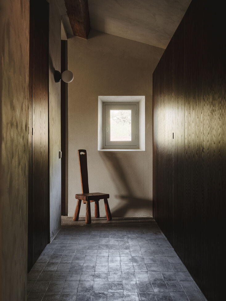 an antique brutalist french chair and eklipso black marble wall sconce from sim 20