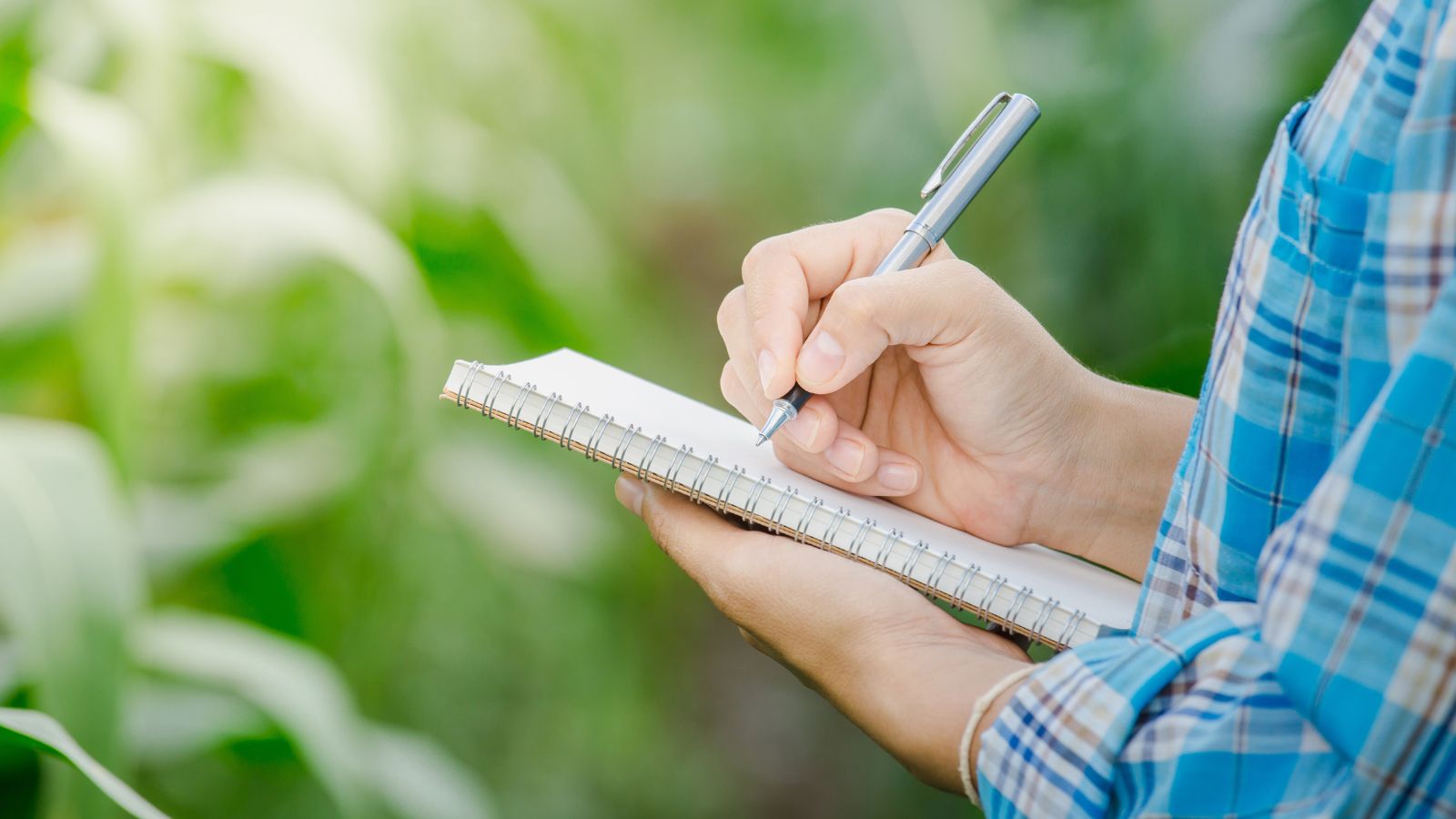 a close-up shot of a person in the process of holding a notebook and keeping track of progress