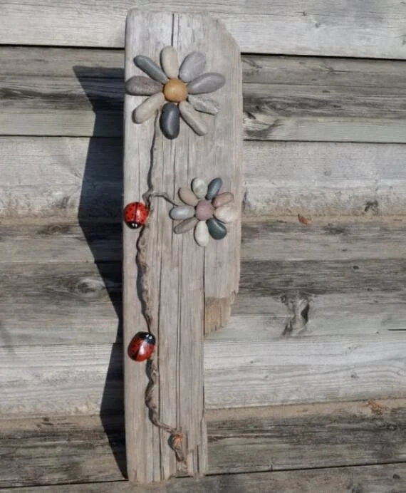 painted rock flower art attached to reclaimed wood with ladybug accents