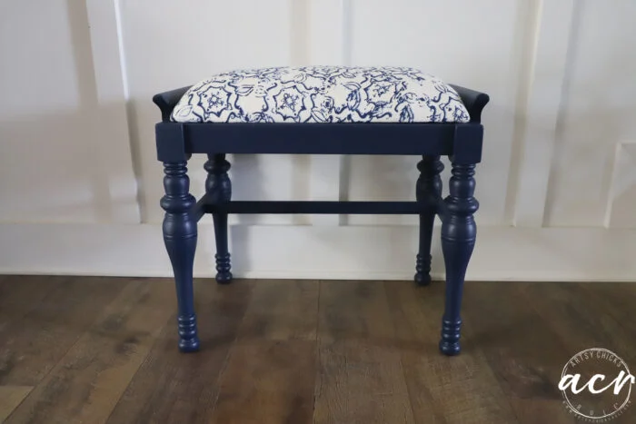 a charming vintage bench with turned legs, a white cushioned seat featuring a blue floral pattern, and a navy blue finish—this piece brings timeless vintage furniture style to any space.