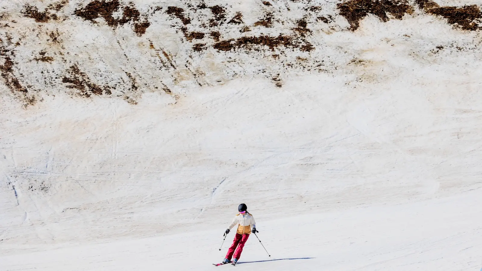 a skier passes by an area of low snow coverage at vail ski resort as temperatures reach into the 50s on march 18, 2026 in vail, colorado.